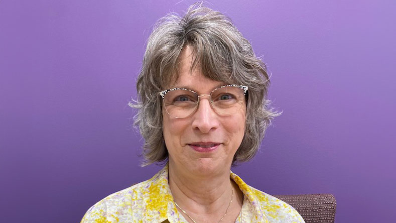 a person with glasses smiling